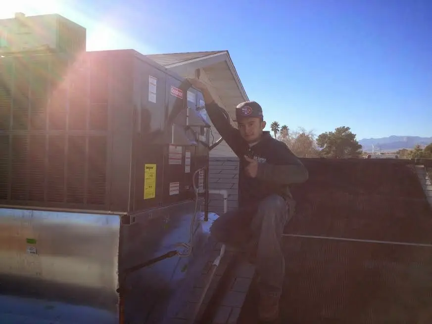 HVAC technician performing Boiler Repair on a rooftop unit in Roscoe